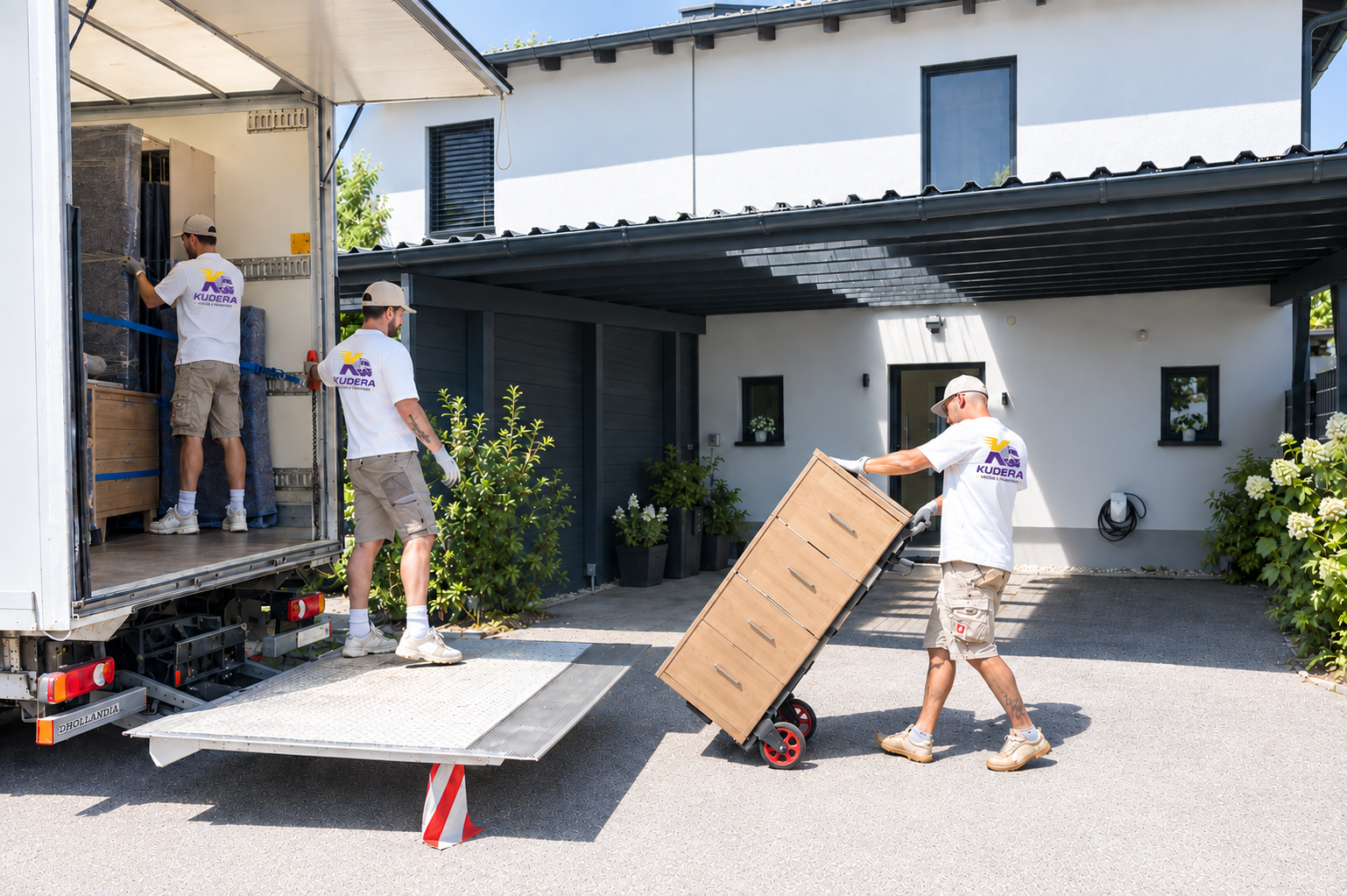 Kudera Team beim Beladen des LKW mit Möbeln vor einem Einfamilienhaus